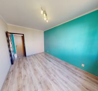 PREDANÉ !!! (74 m²) SVETLÝ 3i BYT S LOGGIOU - Izba s tyrkysovou stenou, veľkým oknom a podlahou s dreveným dekorom v 3-izbovom byte.