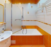 PREDANÉ !!! (74 m²) SVETLÝ 3i BYT S LOGGIOU - Kúpeľňa v 3-izbovom byte s oranžovými obkladmi, sprchou a umývadlom.