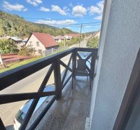 Prenájom 1 izbového bytu v centre obce Oščadnica - Balkón s výhľadom na ulicu Centrum v Oščadnici obklopený zeleňou a domami, 1-izbový byt.