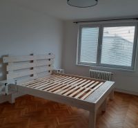 Prenájom 2-izbového bytu, Martin - Sever - Svetlá spálňa s drevenou posteľou a podlahou s dreveným dekorom v 2-izbovom byte.