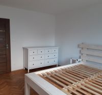 Prenájom 2-izbového bytu, Martin - Sever - Spálňa s bielym nábytkom a podlahou s dreveným dekorom v 2-izbovom byte.