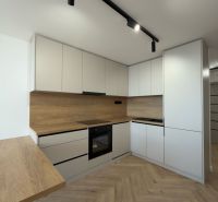 PRIPRAVUJEME: 4 izb. novorekonštruovaný byt, Košice - Terasa, Obrody - Kuchyňa v 4-izbovom byte s podlahou s dreveným dekorom a modernými skrinkami.