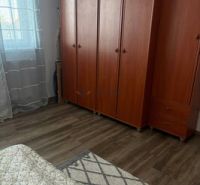 2 iz apartmán v príjemnej lokalite  - Izba v 2-izbovom byte s skriňami a podlahou s dreveným dekorom.