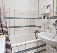 3-izbový byt v centre Pezinka, balkón, výťah, pivnica, komora - Kúpeľňa s vaňou, umývadlom, bielym obkladom a vzorovanými detailmi v 3-izbovom byte.