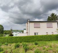 MIMORIADNE ZNÍŽENÁ CENA! Priestranný 6-izbový RD, Nenince, V. Krtíš. - Rodinný dom v Neninciach obklopený hustou zeleňou a stromami pod zamračenou oblohou.