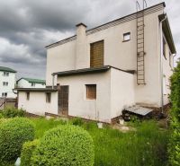 MIMORIADNE ZNÍŽENÁ CENA! Priestranný 6-izbový RD, Nenince, V. Krtíš. - Rodinný dom v Neninciach s trávnikom a kríkmi, pod zamračenou oblohou.