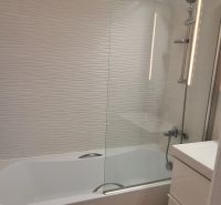 REZERVOVANÉ: 3 izbový byt + 2x balkón, komplet.rekonštr. - KOMÁRNO - Kúpeľňa v 3-izbovom byte s vaňou, bielymi obkladmi a podlahou s dreveným dekorom.