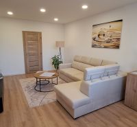 REZERVOVANÉ: 3 izbový byt + 2x balkón, komplet.rekonštr. - KOMÁRNO - Obývacia izba v 3-izbovom byte s podlahou s dreveným dekorom a pohodlnou sedačkou.