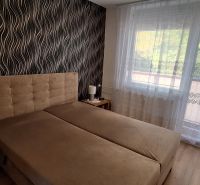 REZERVOVANÉ: 3 izbový byt + 2x balkón, komplet.rekonštr. - KOMÁRNO - Spálňa s čalúnenou posteľou, vzorovaná tapeta, záclony, podlaha s dreveným dekorom.
