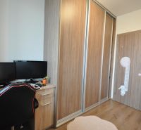 3-IZBOVÝ TEHLOVÝ BYT V DUBNICI NAD VÁHOM | 68 m² | BALKÓN | VLASTNÉ KÚ - Pracovný kút so stolom, dvoma monitormi, šatníkovou skriňou a podlahou s dreveným dekorom.