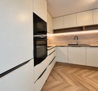 3- izbový byt na Vajanského ulici v Trnave !! 2 terasy !! - Kuchynská linka s bielymi skrinkami a dreveným dekorom v 3-izbovom byte.