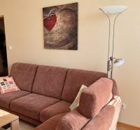 PRENÁJOM | 3-IZBOVÝ BYT | 80 m² | 2 BALKÓNY | ZARIADENÝ | CENTRUM I  - Pohodlná obývačka s pohovkou, lampou a umeleckým obrazom v 3-izbovom byte.