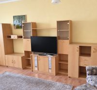 PRENÁJOM | 3-IZBOVÝ BYT | 80 m² | 2 BALKÓNY | ZARIADENÝ | CENTRUM I  - Obývačka v 3-izbovom byte s podlahou s dreveným dekorom, svetlý nábytok, televízor.