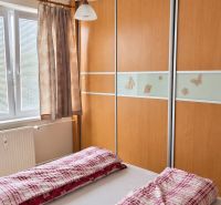 PRENÁJOM | 3-IZBOVÝ BYT | 80 m² | 2 BALKÓNY | ZARIADENÝ | CENTRUM I  - Spálňa v 3-izbovom byte s vstavanou skriňou a posteľou s červeným povlečením.