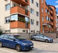 PEZINOK-PRIESTRANNÝ ZARIADENÝ 2i BYT S LOGGIOU A ŠATNÍKOM - Bytovka na ulici Dona Sandtnera v Pezinku s parkoviskom a okolitými autami.