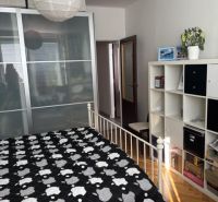 PREDAJ  2 izb. bytu s balkónom v Komárne - Spálňa v 2-izbovom byte s úložným priestorom, posteľou a podlahou s dreveným dekorom.