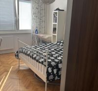 PREDAJ  2 izb. bytu s balkónom v Komárne - Spálňa v 2-izbovom byte s posteľou a podlahou s dreveným dekorom.