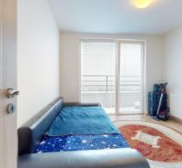 Komplet zariadený 2i byt s panoramatickými výhľadmi a 5.3 m² terasou - Izba v 3-izbovom byte s rozkladacou pohovkou, podlaha s dreveným dekorom, balkónové dvere.