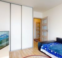Komplet zariadený 2i byt s panoramatickými výhľadmi a 5.3 m² terasou - Spálňa s televízorom, vstavanou skriňou, podlahou s dreveným dekorom v 3-izbovom byte.