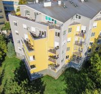 REZERVOVANÉ | Zrekonštruovaný 3i byt na Slávičom údolí s parkovaním - Bytový dom so žltou fasádou obklopený zeleňou na Slávičom údolí v Bratislave.