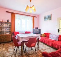 PREDAJ - 4 izbový rodinný dom, Kráľov Brod - Svetlá izba v rodinnom dome s retro nábytkom, kobercom a dekoráciami.