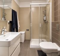 Kvalitne zariadený 2-izbový byt s loggiou, pivnič. kobkou, parkovaním - Kúpeľňa v 2-izbovom byte s moderným sprchovacím kútom, vstavaným umývadlom a svetlými obkladmi.