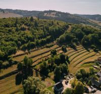 PREDAJ: Pozemky pre rekreačnú chatu, 765 m² – Čierny Balog, Komov - Letecký pohľad na zelené kopce a domy na Školskej ulici v Čiernom Balogu.