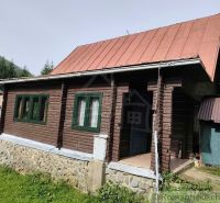 Zariadená chata s krbom pri lese v Rajeckej Lesnej - Drevená chata s plechovou strechou v prírode Rajeckej Lesnej, obklopená zeleňou.