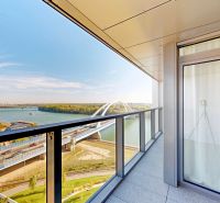 Eurovea Tower – terasa, garážové státie, klimatizácia, Downtown - Balkón 2-izbového bytu na Pribinovej ulici v Bratislave s výhľadom na rieku a most.