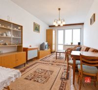 Svetlý a teplý 2-izbový byt s balkónom v centre Spišskej Novej Vsi (52 - Obývacia izba 2-izbového bytu s retro nábytkom, kobercom a sklom vitríny.