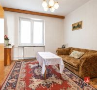 Svetlý a teplý 2-izbový byt s balkónom v centre Spišskej Novej Vsi (52 - Obývacia izba v 2-izbovom byte s kobercom a pohovkou, podlaha s dreveným dekorom.