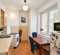 Svetlý a teplý 2-izbový byt s balkónom v centre Spišskej Novej Vsi (52 - Kuchyňa v 2-izbovom byte s podlahou s dreveným dekorom, jedálenským stolom a modernou výbavou.