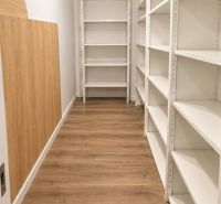 Moderný 2-izbový apartmán, balkón, sklad, Šancová-novostavba PREMIÈRE - Úložný priestor s bielymi regálmi a podlahou s dreveným dekorom v 2-izbovom byte.