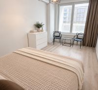 Moderný 2-izbový apartmán, balkón, sklad, Šancová-novostavba PREMIÈRE - Svetlá spálňa v 2-izbovom byte s podlahou s dreveným dekorom a jednoduchým nábytkom.