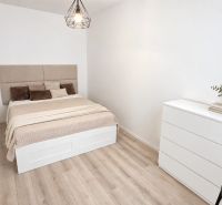 Moderný 2-izbový apartmán, balkón, sklad, Šancová-novostavba PREMIÈRE - Izba v 2-izbovom byte s posteľou, komodou a podlahou s dreveným dekorom.