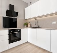 Moderný 2-izbový apartmán, balkón, sklad, Šancová-novostavba PREMIÈRE - Kuchyňa v 2-izbovom byte s bielymi skrinkami a podlahou s dreveným dekorom.
