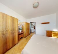 3.izbový byt so záhradou /420 m²/ a chatkou BOŠANY - Spálňa v 3-izbovom byte s nábytkom a podlahou s dreveným dekorom.