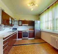3.izbový byt so záhradou /420 m²/ a chatkou BOŠANY - Kuchyňa v 3-izbovom byte s linkou, záclonami a podlahou s dreveným dekorom.