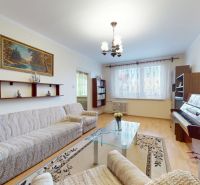 3.izbový byt so záhradou /420 m²/ a chatkou BOŠANY - Obývacia izba v 3-izbovom byte, pohovka, klavír, koberec, podlaha s dreveným dekorom.