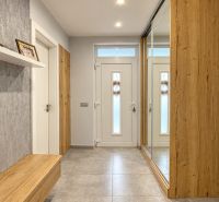 Predaj 4i samostatný rodinný dom, 400 m2 pozemok, Mosonmagyaróvár - Interiér rodinného domu s dreveným dekorom a veľkým zrkadlom v predsieni.