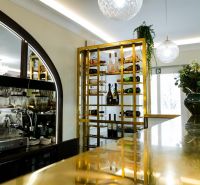 Jedinečná príležitosť - reštaurácia s kompletným konceptom a zázemím - Elegantná vinotéka a bar v obchodných priestoroch s moderným osvetlením a zlatými detailmi.