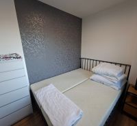 DOBRÉ REALITY - krásny 1,5-i. byt s lódžiou na prenájom, Kanianka - Spálňa v 1-izbovom byte s tmavou stenou a podlahou s dreveným dekorom.