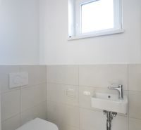 Moderné bývanie s priestorom a vlastnou záhradou - Toaleta s umývadlom v 3-izbovom byte, jednoduchá biela a sivá farebná schéma.