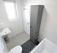 Moderné bývanie s priestorom a vlastnou záhradou - Kúpeľňa v 3-izbovom byte s vaňou, umývadlom a skrinkou.