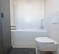 Moderné bývanie s priestorom a vlastnou záhradou - Kúpeľňa s vaňou a závesným WC v 3-izbovom byte. Minimalistický dizajn.
