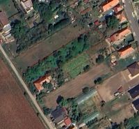 Stavebný pozemok v obci Jasová - Pozemky na bývanie v Jasovej s vyznačeným územím, obklopené zeleňou a budovami.