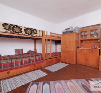 Starší rodinný dom s veľkou záhradou v obci Štefanová | okres Pezinok - Interiér rodinného domu s poschodovou posteľou, komodami a podlahou s dreveným dekorom.