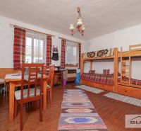 Starší rodinný dom s veľkou záhradou v obci Štefanová | okres Pezinok - V rodinnom dome je poschodová posteľ, stôl a podlaha s dreveným dekorom.