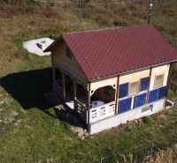 Na predaj Chata Horná Breznica, pozemok 5084 m2, POLOSAMOTA - Chata v Horná Breznici s dreveným obkladom a červenou strechou na zelenom pozemku.