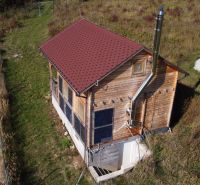 Na predaj Chata Horná Breznica, pozemok 5084 m2, POLOSAMOTA - Chata v Hornej Breznici na svahu s dreveným obkladom a solárnymi panelmi.